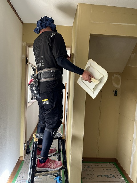 新築住宅の壁にクロスを張る内装職人さん