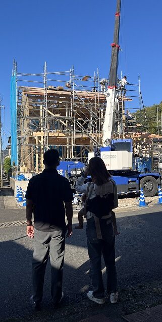 上棟の日に組み上がっていく新築住宅の骨組みを見学するお施主様