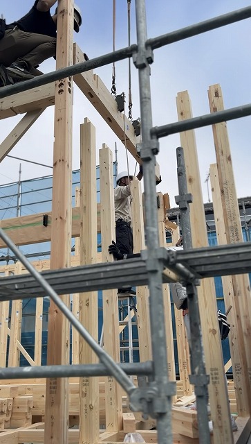 木造住宅の上棟工事でクレーンを使って梁を吊り上げる建て方作業